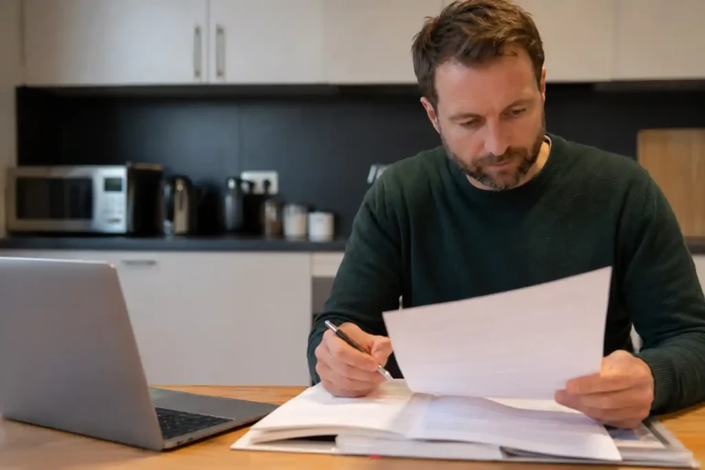 Landlord reviewing HMO compliance checklist document, Manchester residential property exterior, Fire safety compliance certificate, HMO compliance Manchester, HMO regulations landlord, HMO management standards